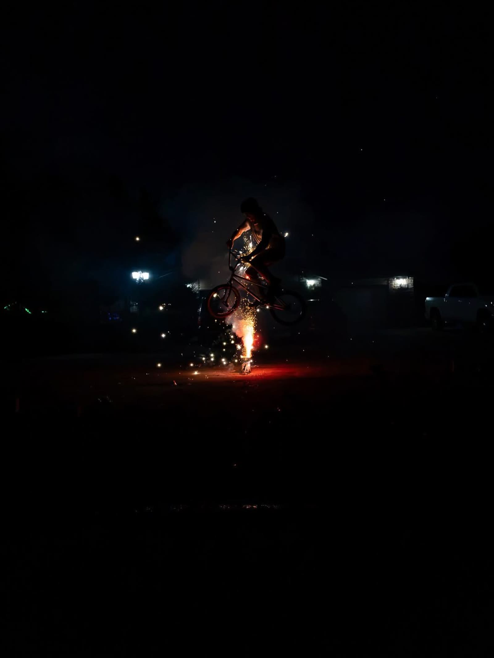 Melville Smith silhouetted against sparks at night